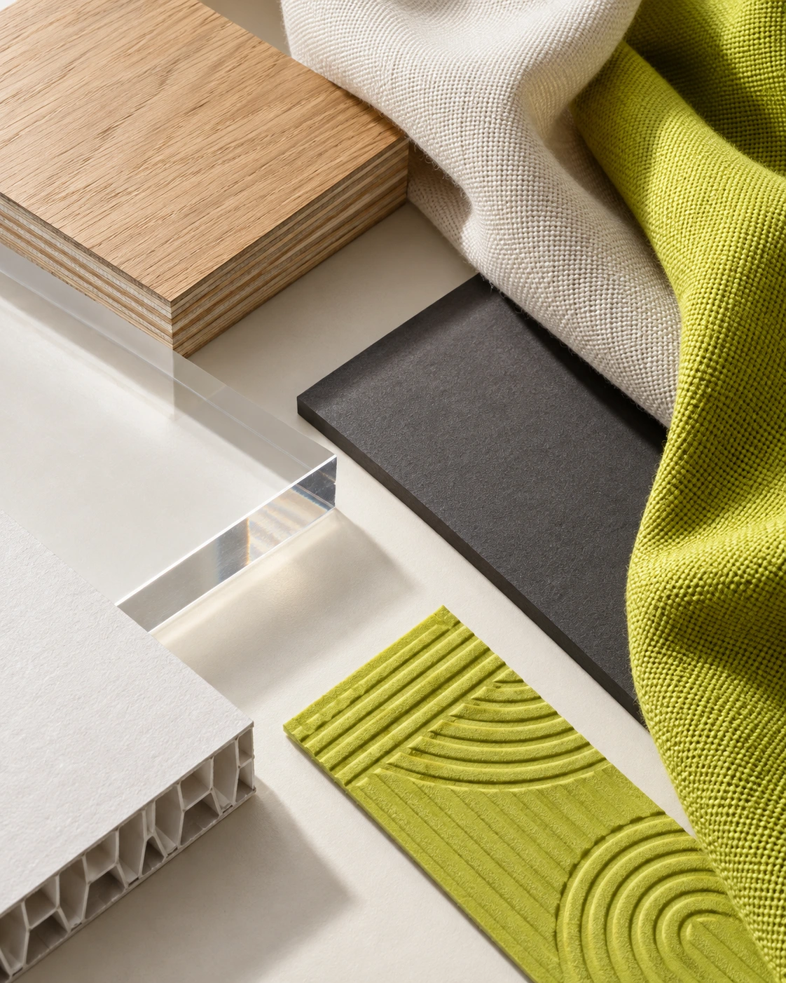 Concept image of material samples: timber, clear acrylic, charcoal board, woven fabric and a lime textured tile