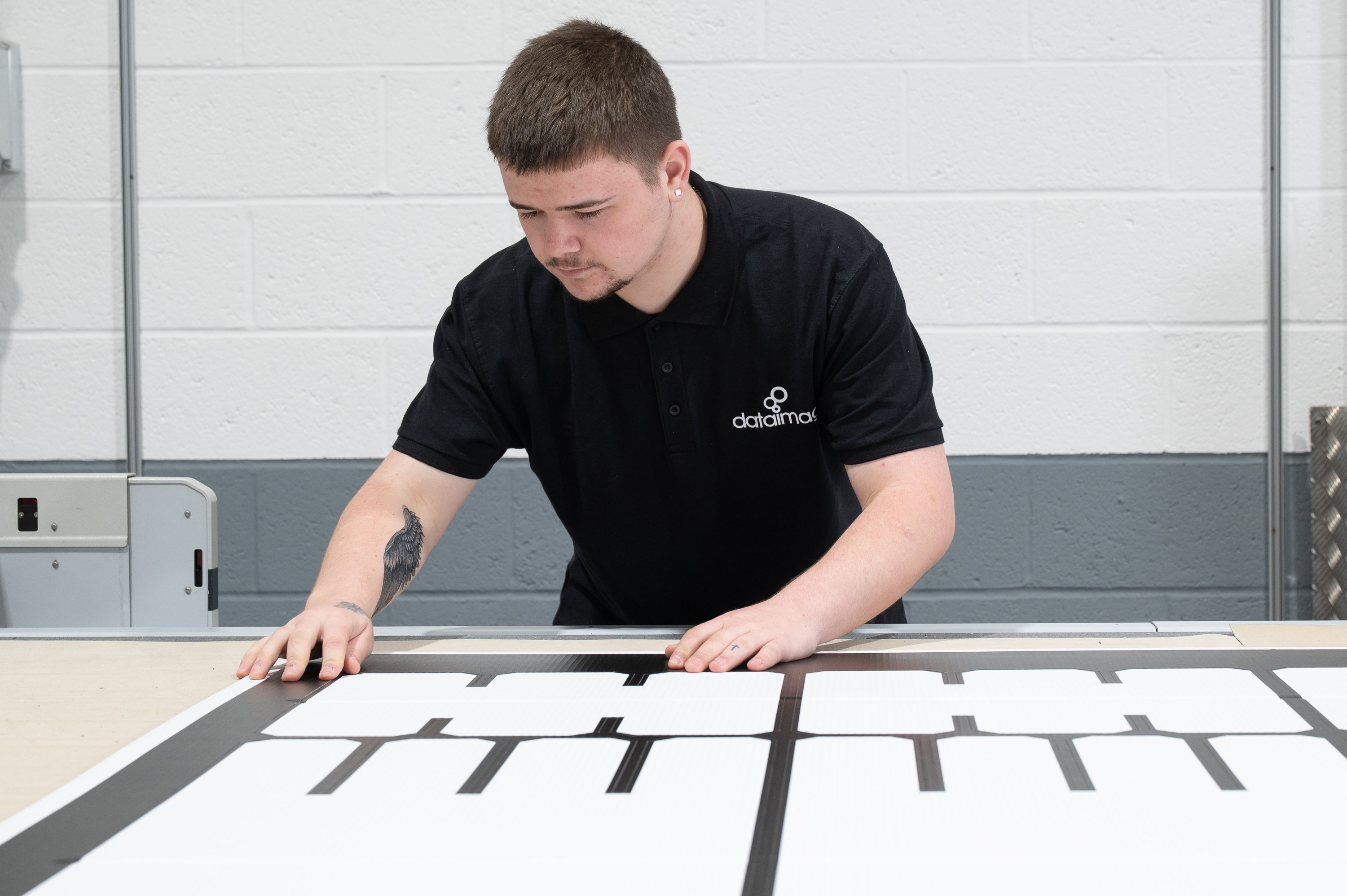 A POS Display Manufacturer team member inspects display components during the production process to ensure quality and precision.