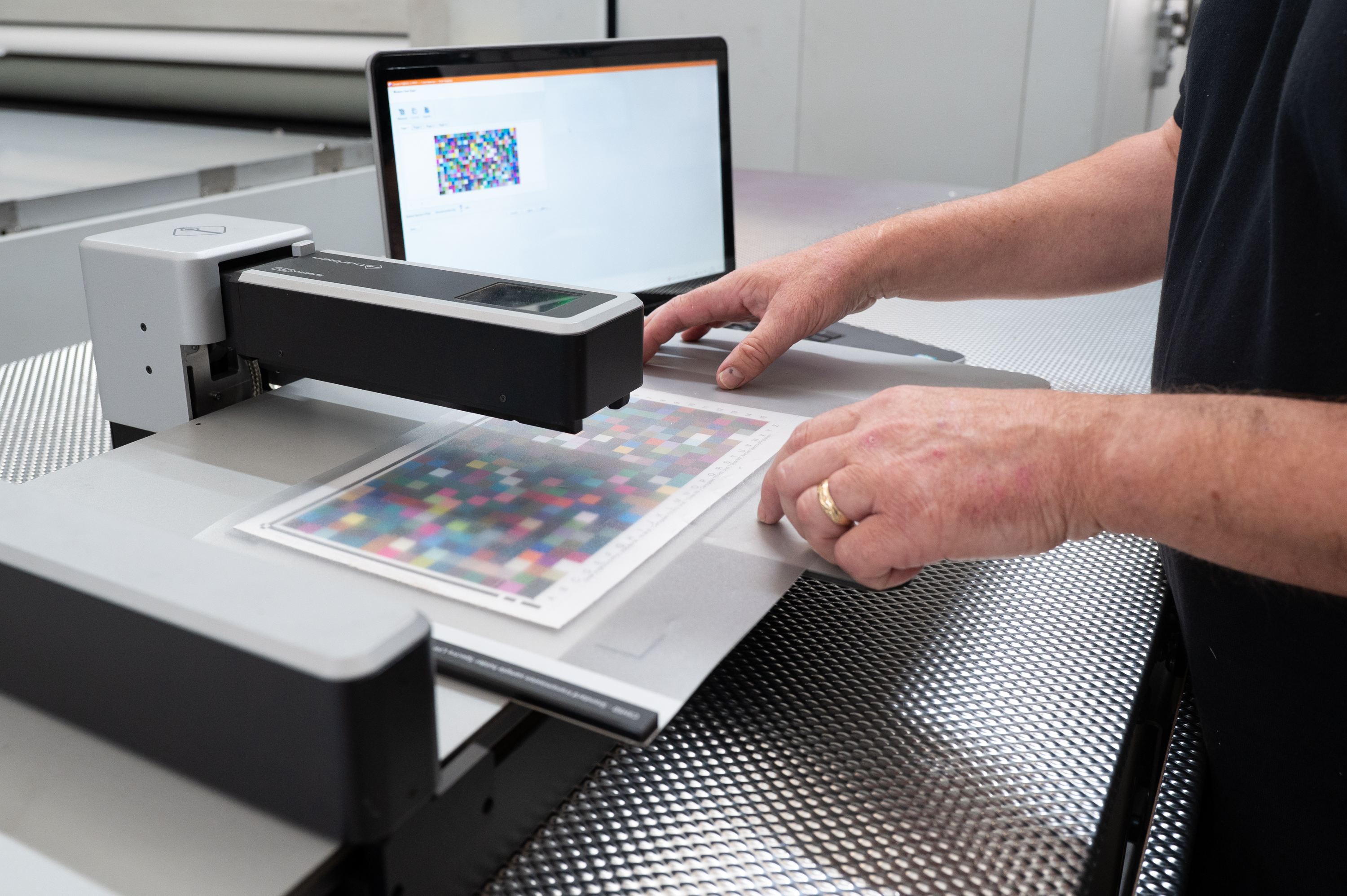 Print technician checking colour calibration samples for branded Cosmetic Displays to ensure accurate and consistent print quality.